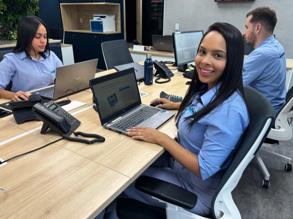 Equipe de automação industrial trabalhando em escritório moderno, com computadores e equipamentos de controle.