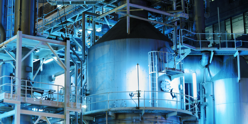 Equipamento industrial com sistema de automação, tubulação e controle de exaustão em ambiente iluminado.