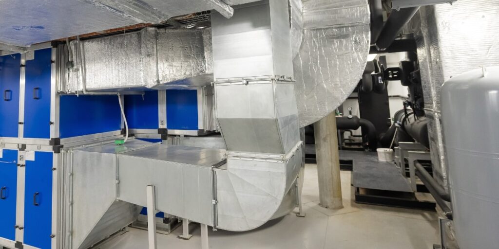 Sistema de exaustão industrial com tubulação de despoeiramento e equipamentos pneumáticos para controle de eficiência.