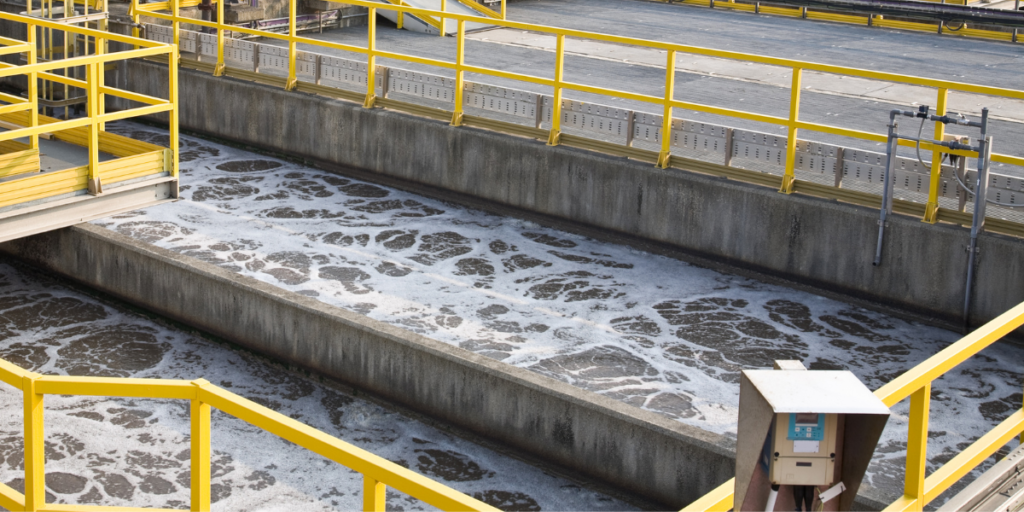 Sistema de tratamento de água com tubulação, sensores e estrutura de controle em ambiente industrial.
