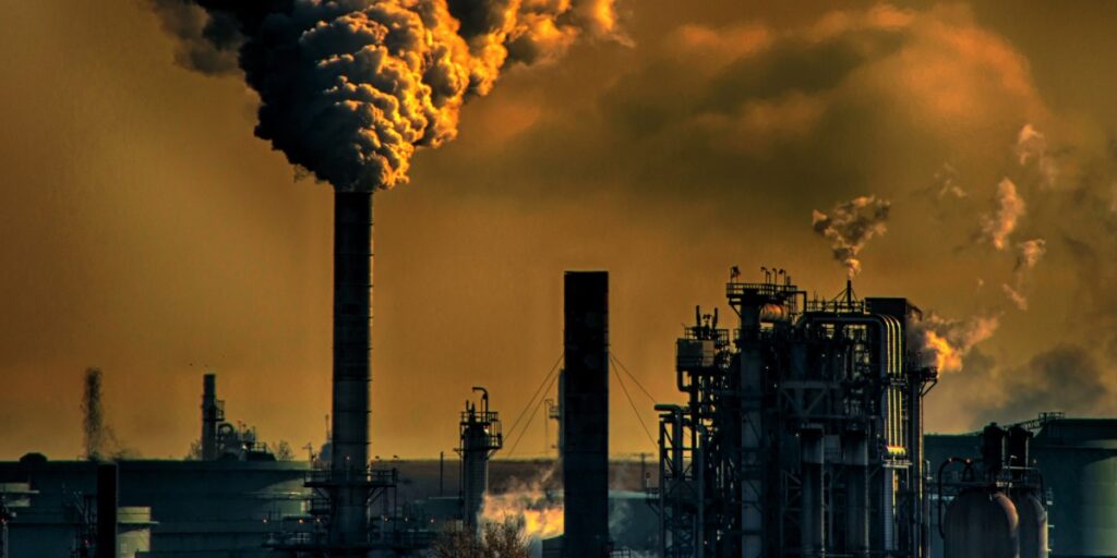 Chaminés industriais liberando fumaça em ambiente de automação, destacando sistemas de controle e despoeiramento.